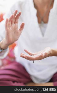 Mindful woman sitting in lotus position, meditating, performing respect gesture with her hands. Spiritual awakening.. Respect