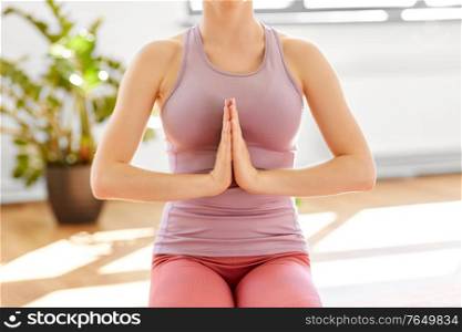 mindfulness, spirituality and healthy lifestyle concept - close up of woman meditating at yoga studio. woman meditating at yoga studio