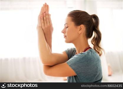 mindfulness, spirituality and healthy lifestyle concept - woman meditating at yoga studio. woman meditating at yoga studio