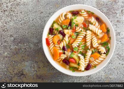 Minestrone soup. Vegetable soup with fresh tomato, celery, carrot, zucchini, onion, pepper, beans and pasta. Dish of italian cuisine.
