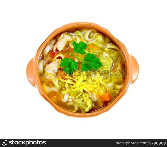 Minestrone soup with meat, celery, tomatoes, zucchini and cabbage, green peas, carrots and pasta in a clay bowl isolated on white background on top