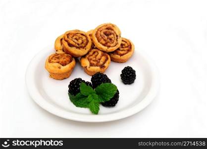 Mini Cinnamon Rolls And Blackberry. Sweet and delicious cinnamon rolls with fresh ripe black berries and a mint leaf garnish ready for a light breakfast or snack