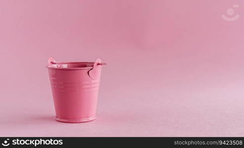 Mini colored tin pail or bucket on pink background with copy space for household items concept