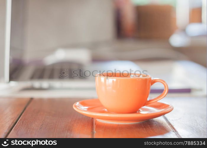 Mini orange coffee cup on work station, stock photo