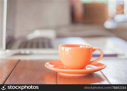 Mini orange coffee cup on work station, stock photo