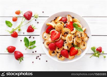 Mini pancakes with fresh strawberry and chocolate drops