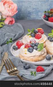 Mini pavlova cakes with fresh raspberries and blueberries