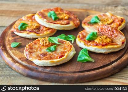 Mini pizzas on the wooden board close-up
