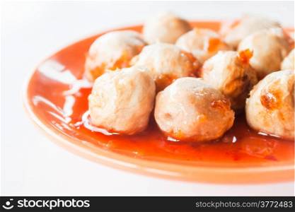 Mini pork balls in orange dish on clean table