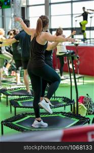 Mini Rebounder Workout - People doing Fitness Exercise in Class at Gym with Music and Teacher on Stage.. Mini Rebounder Workout - People doing Fitness Exercise in Class at Gym with Music and Teacher on Stage