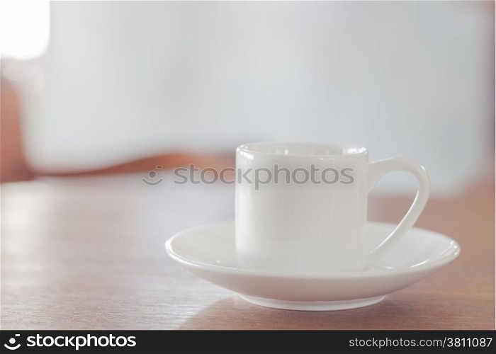 Mini white coffee cup on wooden table, stock photo