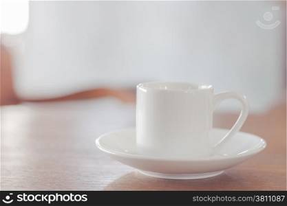 Mini white coffee cup on wooden table, stock photo