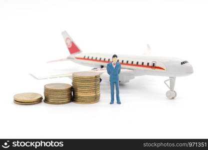 Miniature businessman standing on coins and the airplane behind. saving and loan concept.