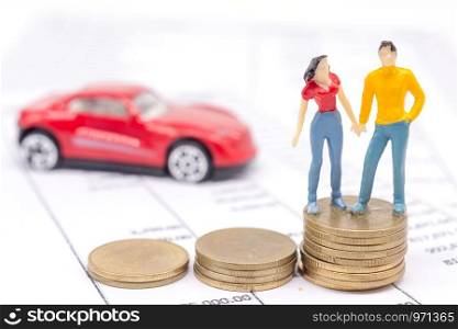 Miniature couple people and stack coins on statement and the car behind. saving and loan concept.