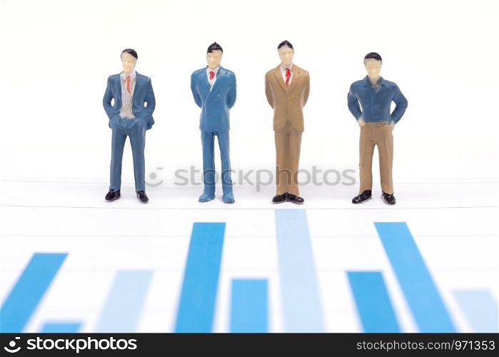 Miniature figures businessmen standing on a graph chart financial