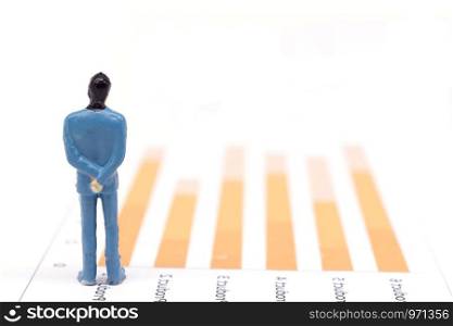 Miniature figures businessmen standing on a graph chart financial