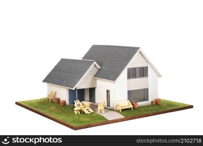 Miniature house with garden furniture isolated over white background