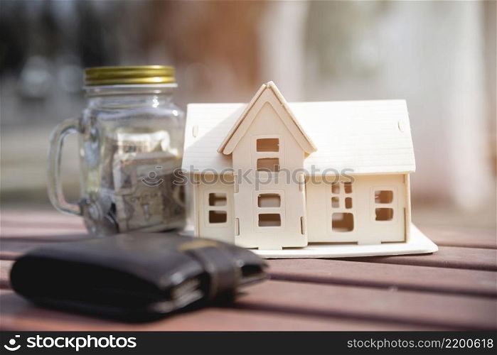 miniature house with savings jar wallet