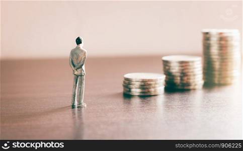 Miniature people looking future with stack coin about financial and money savings concept.