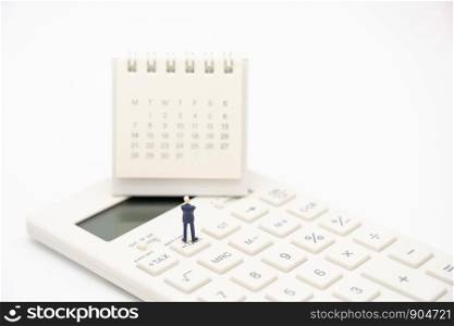 Miniature people Pay queue Annual income (TAX) for the year on calculator. using as background business concept and finance concept with copy space for your text or design.