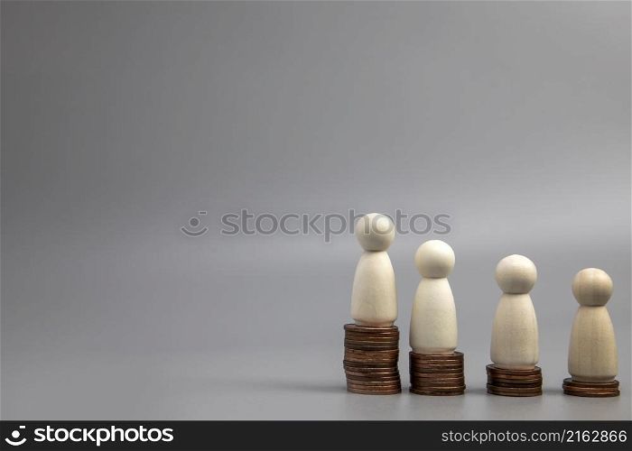 Miniature people standing on piles of different heights of coins. The concepts of person and wealth. investment and teamwork growth copy space. Miniature people standing on piles of different heights of coins. The concepts of person and wealth. investment and teamwork growth