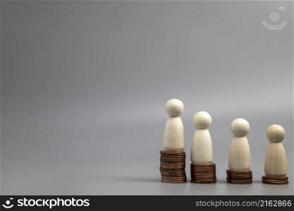 Miniature people standing on piles of different heights of coins. The concepts of person and wealth. investment and teamwork growth copy space. Miniature people standing on piles of different heights of coins. The concepts of person and wealth. investment and teamwork growth