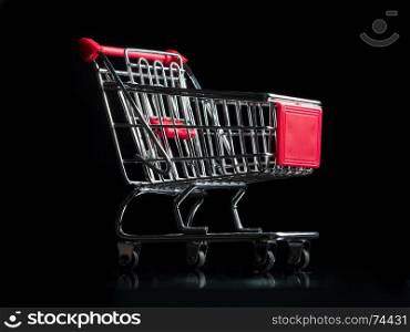 Miniature shopping cart on black background