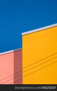 Minimal Architecture Background of Colorful vintage Building Wall against blue clear sky in low angle view and Vertical frame