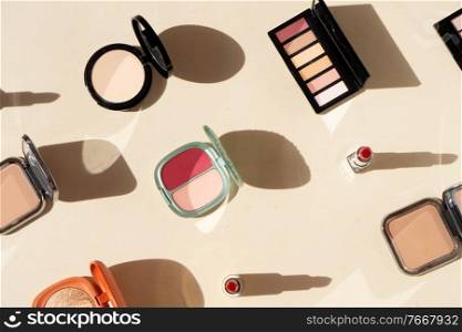 Minimal cosmetic scene with make up brushes, blush, powder, eye shadows, lipstick. make up brushes