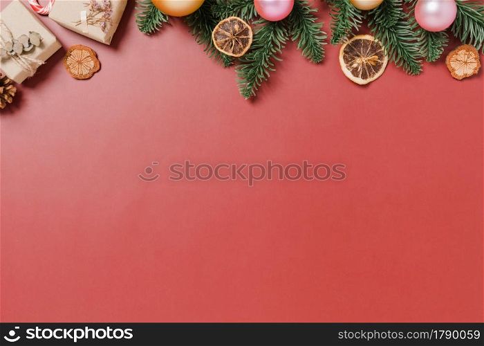 Minimal creative flat lay of christmas traditional composition and new year holiday season. Top view winter christmas decorations on red background with blank space for text. Copy space photography.