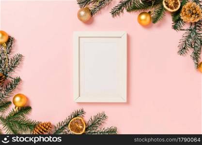 Minimal creative flat lay of winter christmas traditional composition and new year holiday season. Top view mockup black picture frames for text on pink background. Mock up and copy space photography.