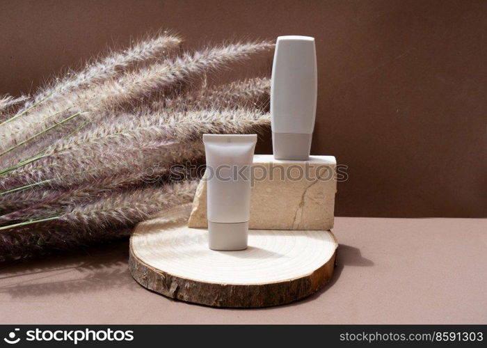 Minimal modern cosmetic products display with two tubes on natural earth tones background with shadow overlay. Minimal product display