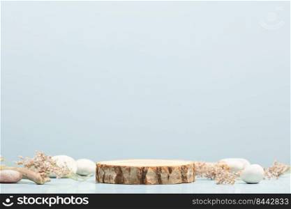 Minimal modern product display on blue background. Wood slice podium, dry flowers and stones. Concept scene stage showcase for new product, promotion sale, banner, presentation, cosmetic. Eco friendly, natural beauty