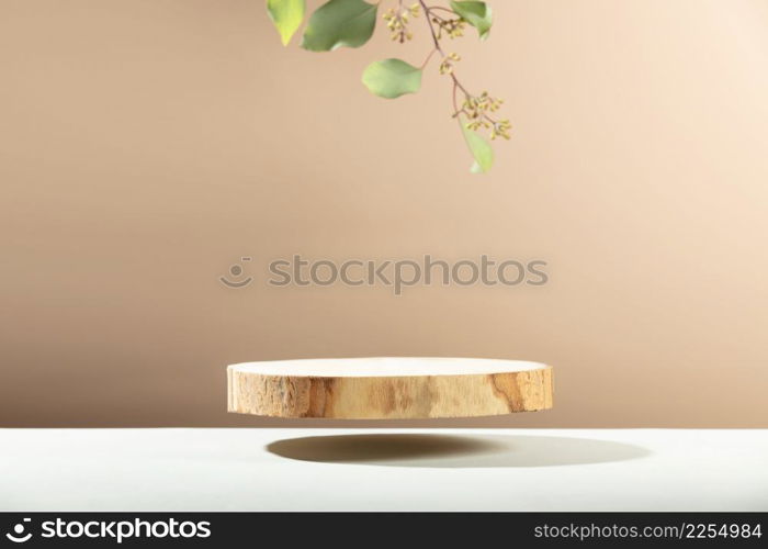 Minimal modern product display on neutral beige background. Wood slice podium and green eucalyptus leaves. Concept scene stage showcase for new product, promotion sale, banner, presentation, cosmetic