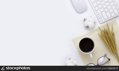 Minimal Office desk table top view with Keyboard computer, mouse, Glasses,  coffee cup Rice plant, sack on a white table with copy space, White color workplace composition, flat lay