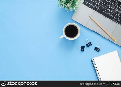 Minimal work space - Creative flat lay photo of workspace desk. . Minimal work space - Creative flat lay photo of workspace desk. Top view office desk with laptop, notebooks and coffee cup on blue color background. Top view with copy space, flat lay photography.