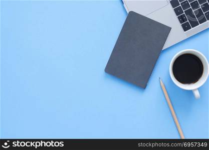 Minimal work space - Creative flat lay photo of workspace desk. . Minimal work space - Creative flat lay photo of workspace desk. Top view office desk with laptop, notebooks and coffee cup on blue color background. Top view with copy space, flat lay photography.