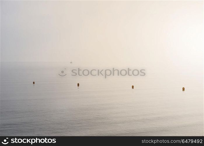 Minimalist fine art image of buoys at sea during foggy morning. Fine art minimalist image of buoys at sea during foggy morning