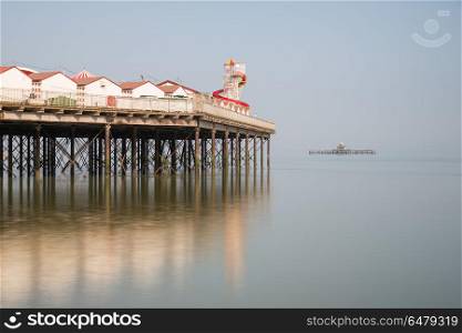 Minimalist fine art landscape image of colorful pier in juxtapos. Minimalist fine art image of colorful pier in juxtaposition with old derelict pier in background