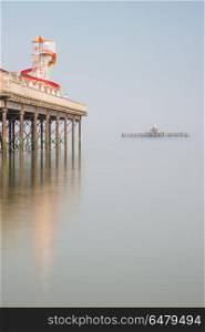 Minimalist fine art landscape image of colorful pier in juxtapos. Minimalist fine art image of colorful pier in juxtaposition with old derelict pier in background