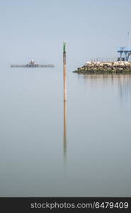 Minimalist fine art landscape image of lifeguard tower in juxta. Minimalist fine art image of lifeguard tower in juxtaposition with old derelict pier in background