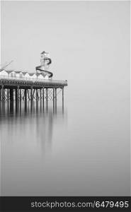 Minimalist fine art landscape image of new pier in juxtaposition. Minimalist fine art image of new pier in juxtaposition with old derelict pier in background in black and white