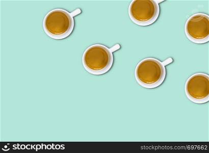 minimalist pattern with a top view of a group of coffee cups on a light green pastel table. Flat lay photography