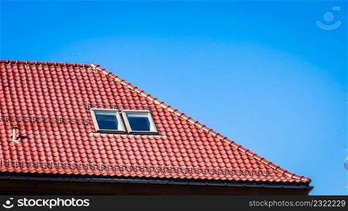 Minimalist shot of roof with red tiles on clear blue sky background.. Minimalist shot of red roof on blue sky