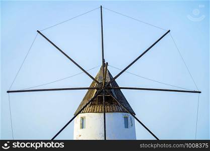 Minimalist view of antique windmill against blue sky. Minimalist view of antique windmill