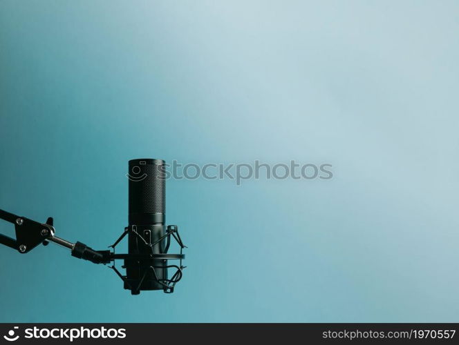 Minimalistic image of a streaming microphone over an pastel blue background with copy space, minimal concept, technology streaming