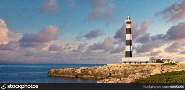 MINORCA ISLE - SPAIN - CIRCA AUGUST 2020  scenic Artrutx Lighthouse at sunset, famous landmark of the Isle