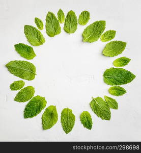 Mint leaves composition on white stone background, flat lay. Mint leaves composition, flat lay, top view