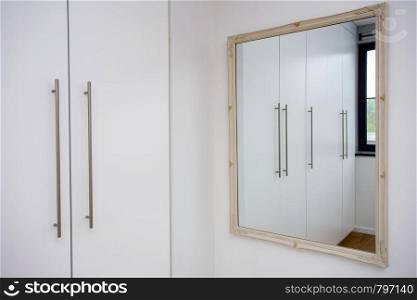 Mirror in white closet room, wardrobe modern design, white and clean close-up. Mirror in white closet room, wardrobe modern design, white and clean