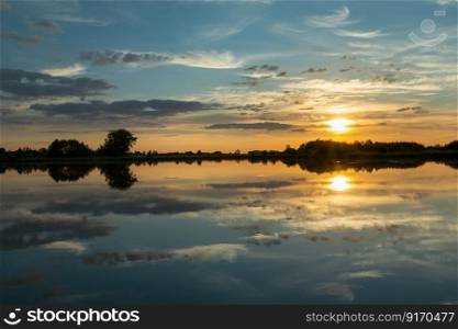 Mirror reflection of clouds in the calm lake water during sunset
